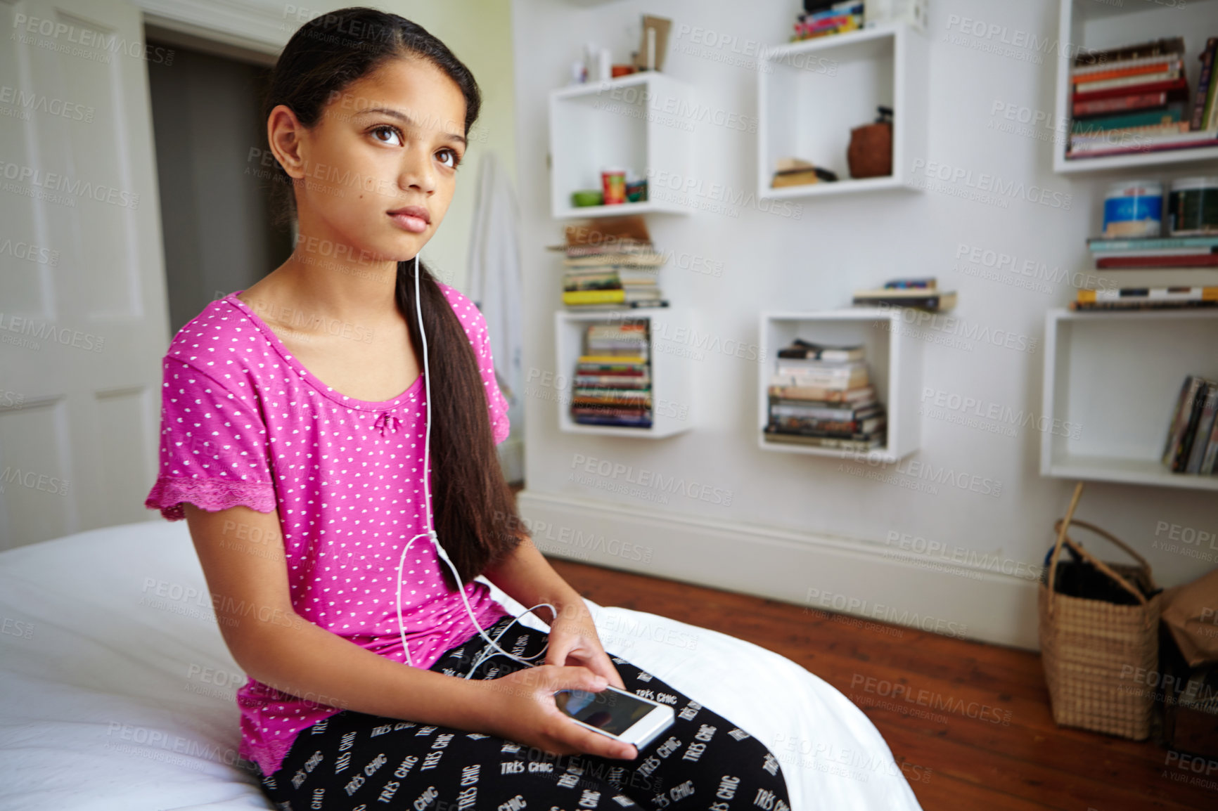 Buy stock photo Shot of a teenage girl listening to music in her bedroom