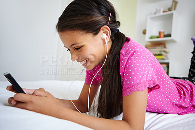 Buy stock photo Shot of a teenage girl listening to music in her bedroom