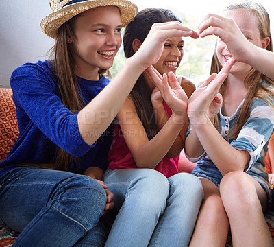 Buy stock photo Shot of a group of teenage friends using their hands to make the shape of a heart