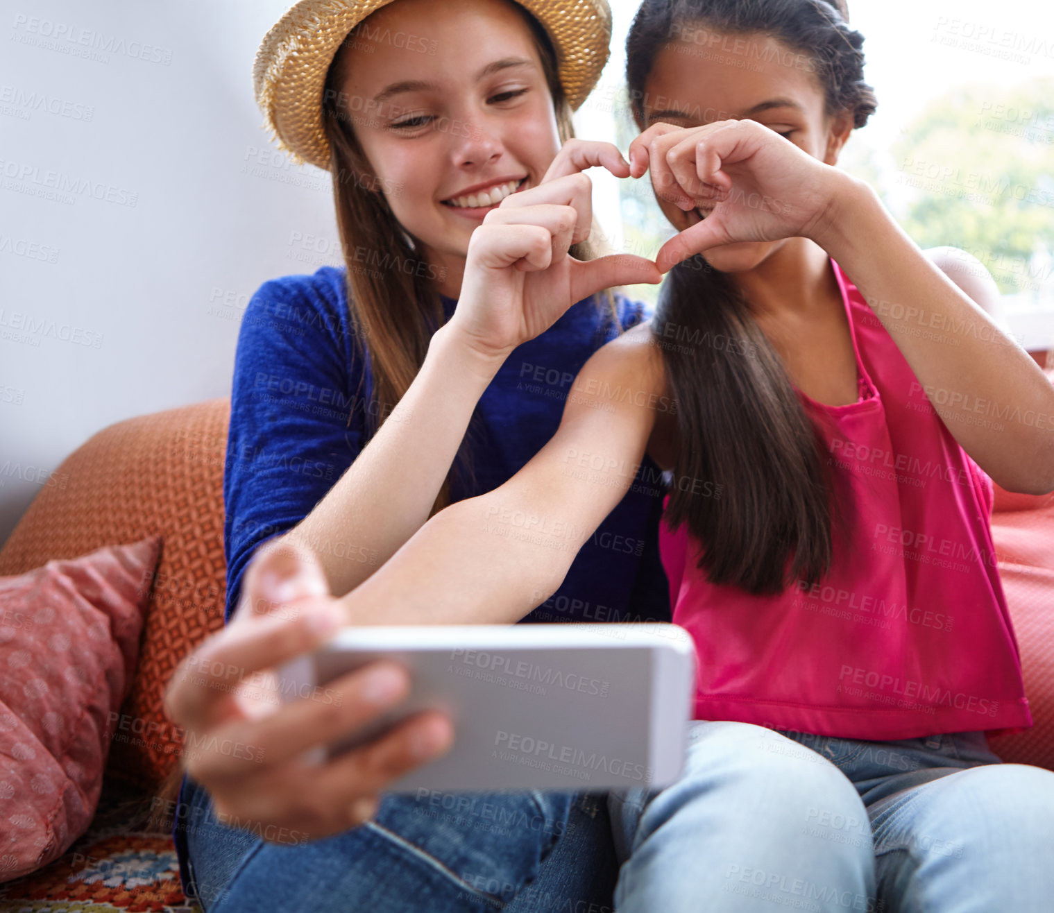 Buy stock photo Shot of two teenage friends taking a selfie while making a heart shape with their hands