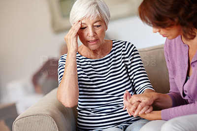 Buy stock photo Shot of a woman sitting beside her elderly mother who's feeling unwell