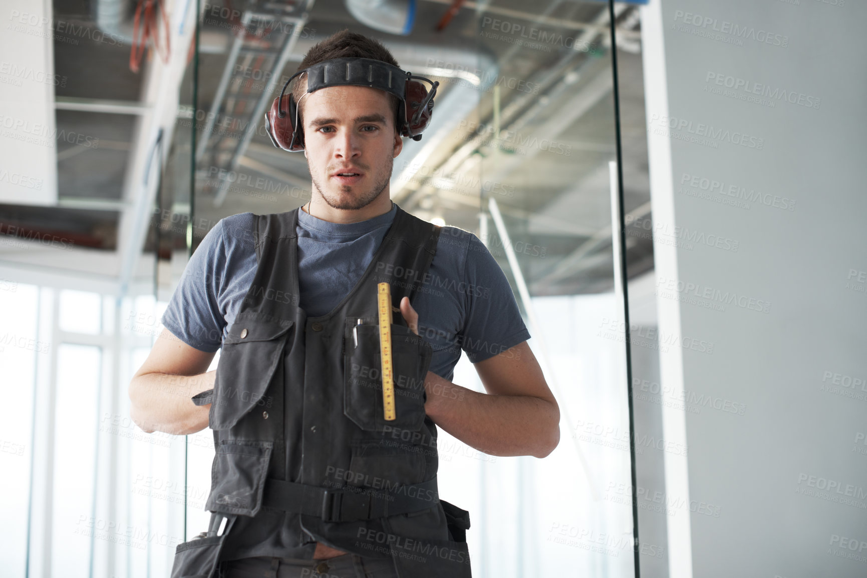 Buy stock photo Handsome young contractor standing on a construction site