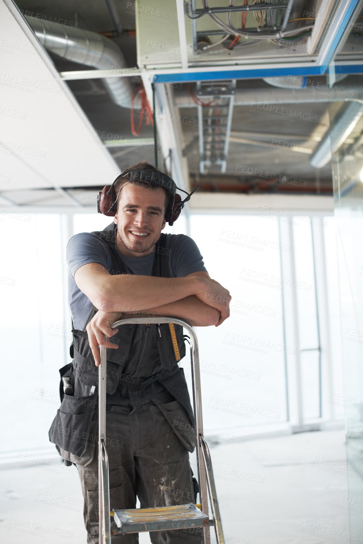 Buy stock photo Handsome young contractor standing on a construction site