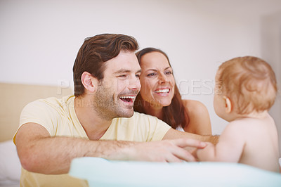 Buy stock photo Two joyful parents bonding with their baby daughter at bathtime