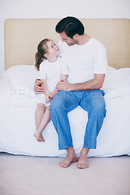 Buy stock photo A loving father and daughter sitting next to each other on a bed