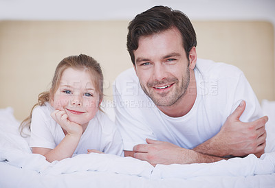 Buy stock photo A father and daughter lying side by side on a bed