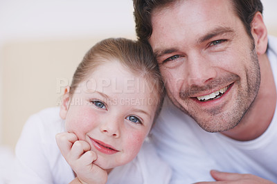 Buy stock photo Closeup shot of a father and daughter lying cozily next to each other