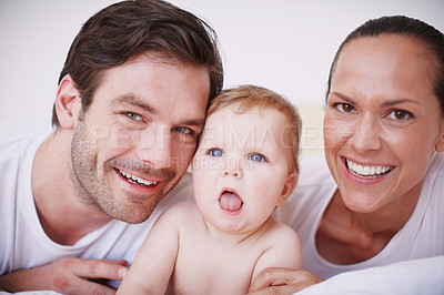 Buy stock photo Portrait of two loving young parents and their adorable baby girl