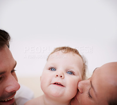 Buy stock photo Two loving young parents showing affection to their adorable baby girl