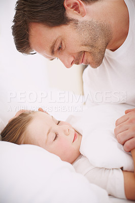 Buy stock photo Side view of a dad looking down lovingly at his sleeping daughter