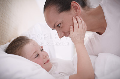 Buy stock photo Closeup shot of a mom putting her young daughter to bed