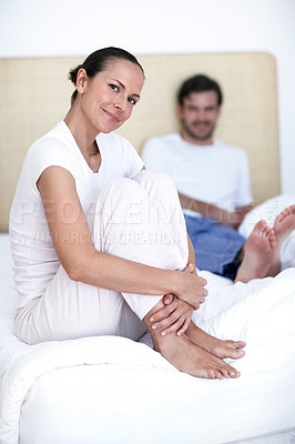 Buy stock photo Portrait of a young married couple sitting together on their bed