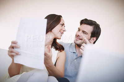 Buy stock photo Low-angle view of a young couple animatedly discussing their home finances