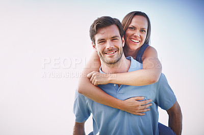 Buy stock photo A handsome man piggybacking his loving wife outdoors