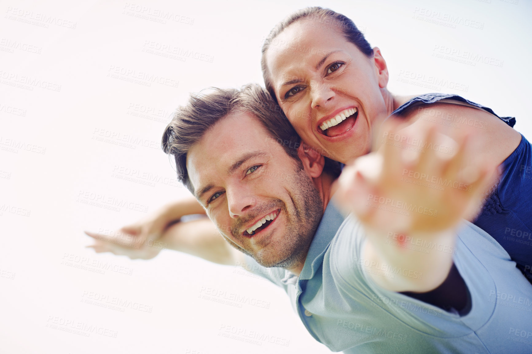 Buy stock photo A handsome man piggybacking his loving wife outdoors