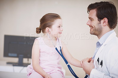 Buy stock photo A little girl reverses roles with her doctor by using his stethoscope on him