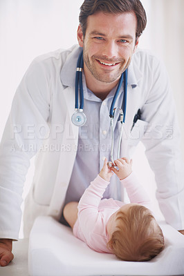 Buy stock photo Portrait of a young male doctor standing by an infant patient