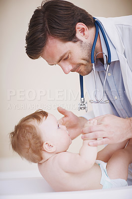 Buy stock photo A male doctor doing a physical examination of an infant girl