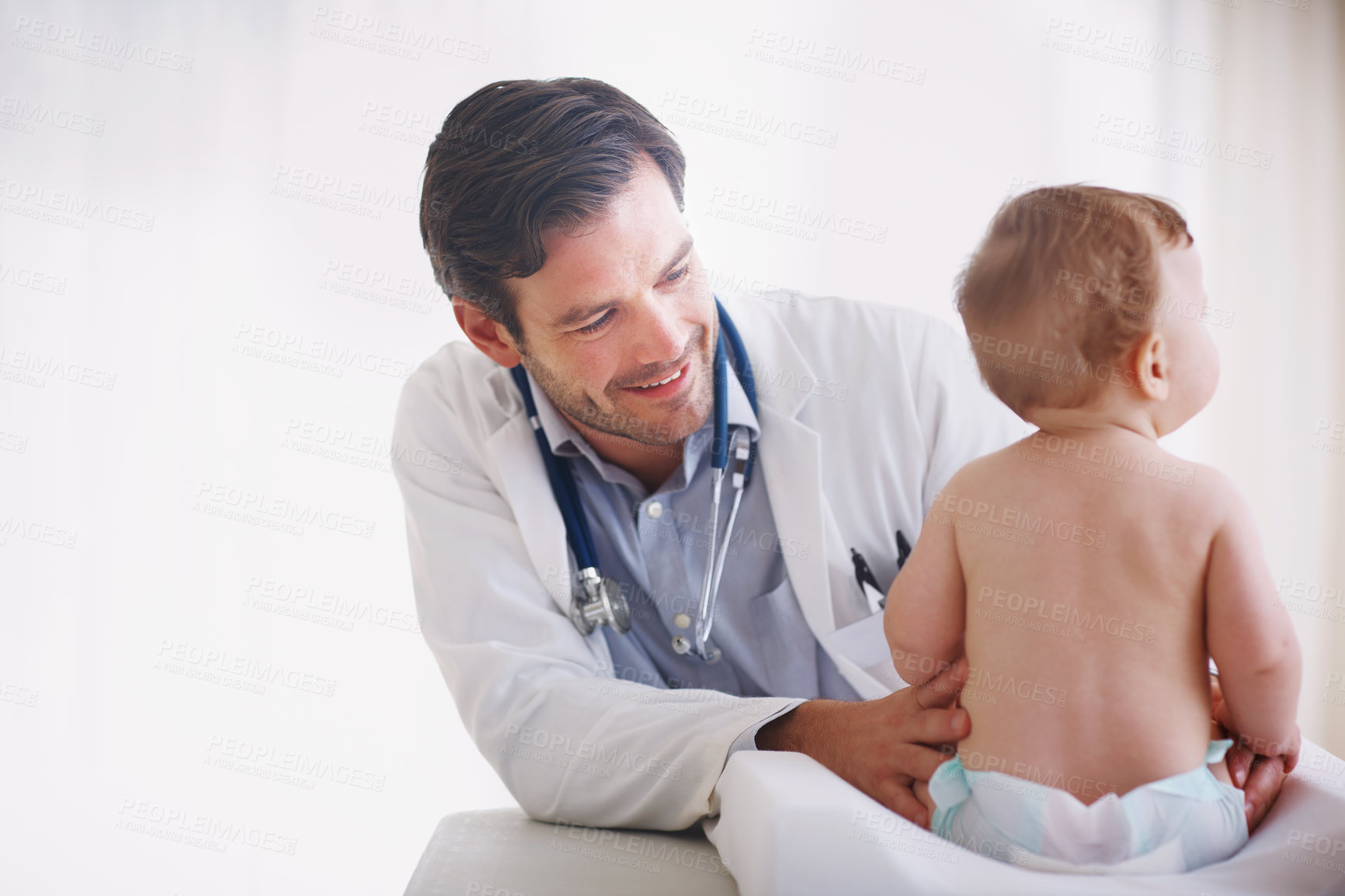 Buy stock photo A young male doctor examining an infant girl