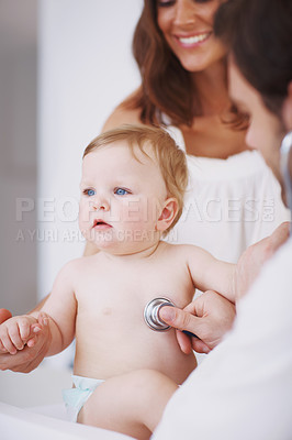 Buy stock photo A mother standing by as her baby daughter is being examined by a pediatrician