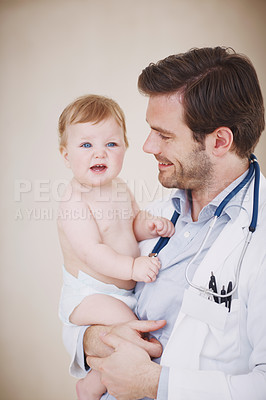 Buy stock photo A male pediatrician holding a patient in his arms