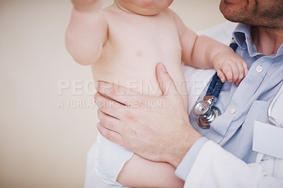 Buy stock photo Cropped shot of a male doctor holding an infant in his arms