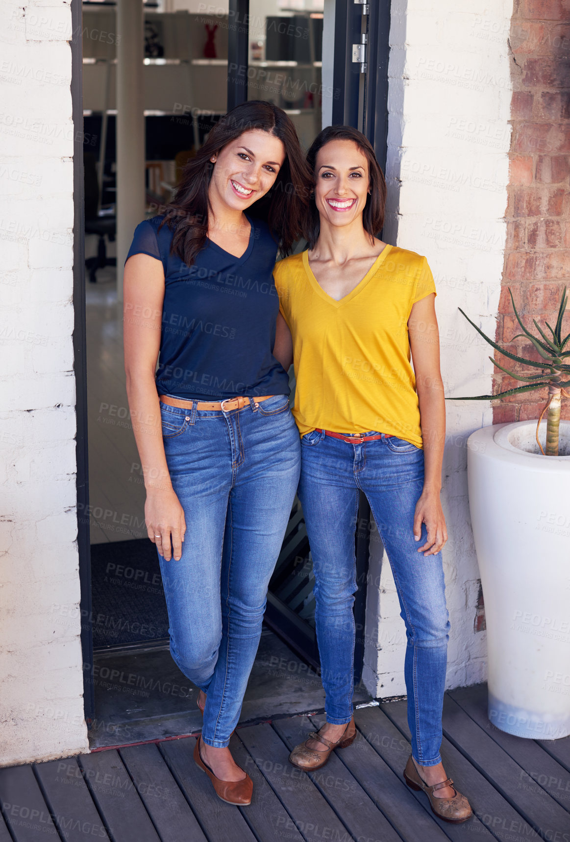 Buy stock photo Two young women standing in front of their workplace