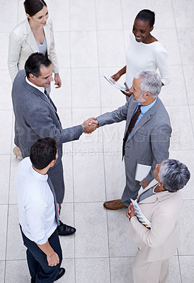 Buy stock photo Team, handshake and happy business people with CEO for deal, collaboration or partnership agreement for diverse financial advisors. Top view, shaking hands and group in office meeting for acquisition