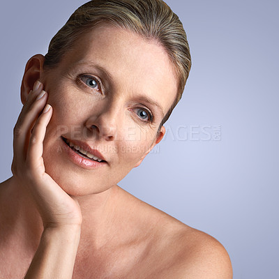 Buy stock photo Face, beauty and mature woman with skincare or cosmetic facial isolated in a blue studio background. Cosmetics, self care and old female model calm with natural skin due to anti aging dermatology