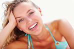 Closeup of a happy female in bikini against bright background