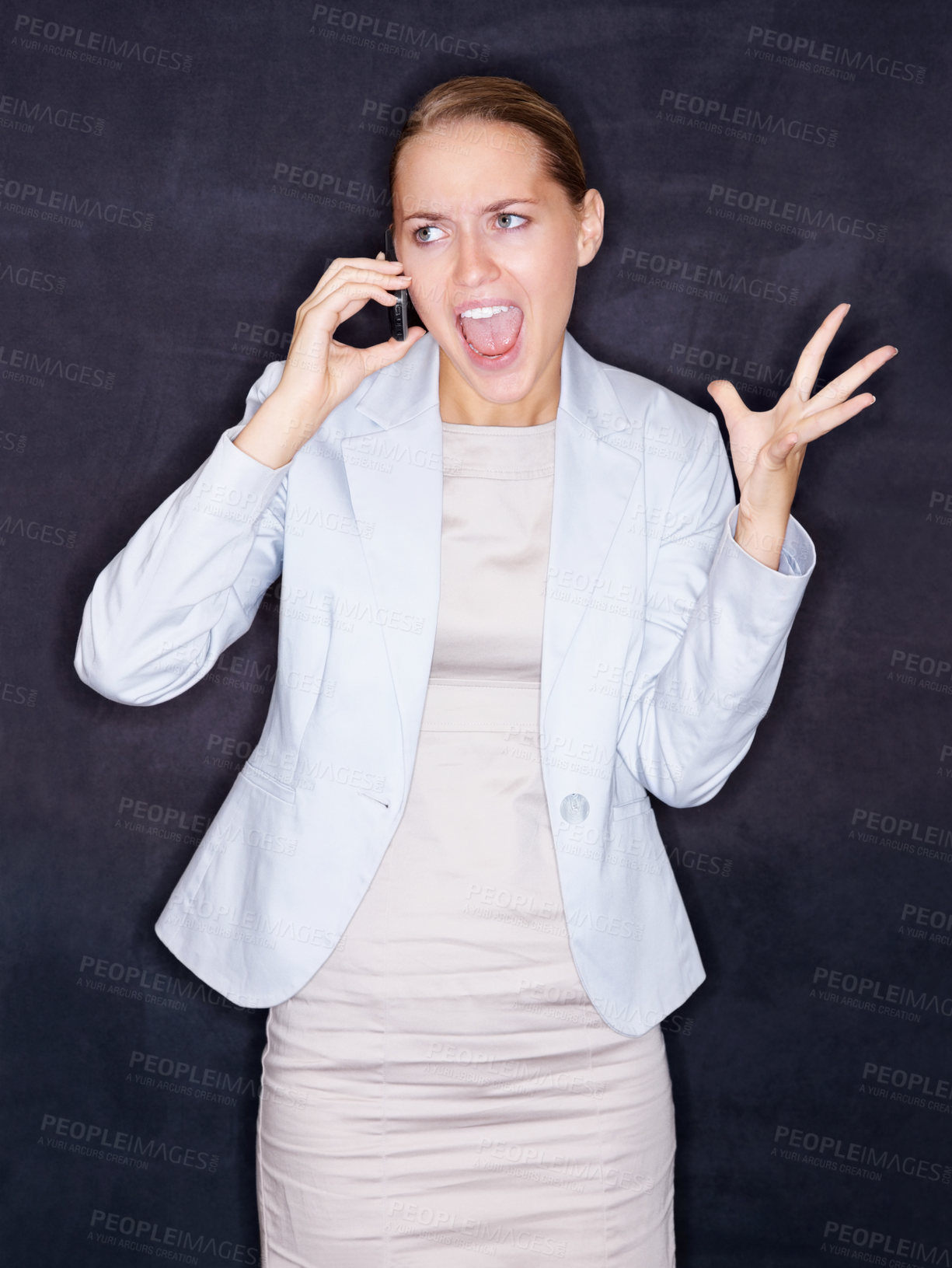 Buy stock photo Angry young business woman screaming over the cellphone against black background