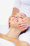 Happy female receiving a facial massage from a masseuse