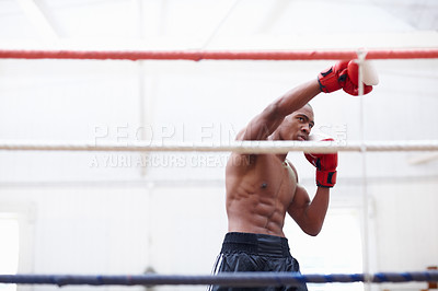 Buy stock photo African American athletic man practicing with boxing gloves in ring