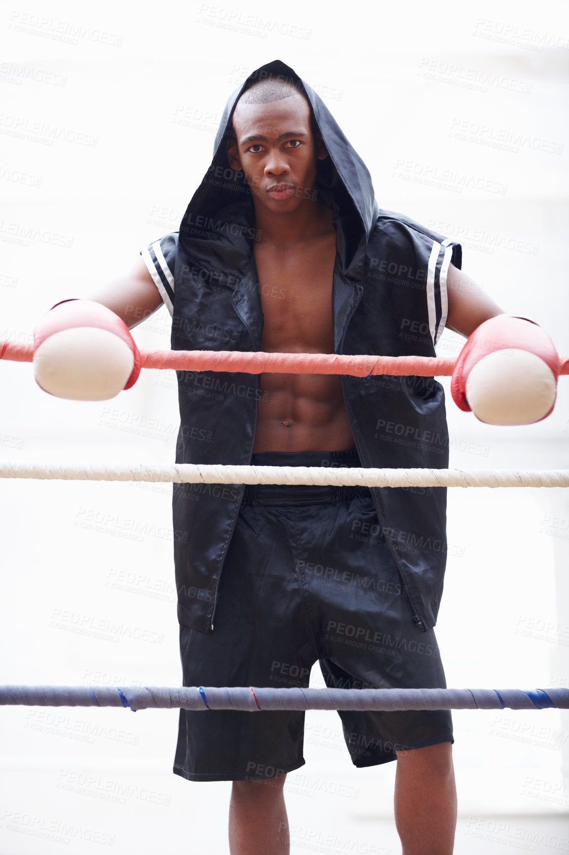 Buy stock photo Portrait of African American athletic man in black hooded robe wearing boxing gloves