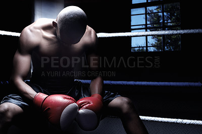 Buy stock photo African American male athletic sitting in ring with head down