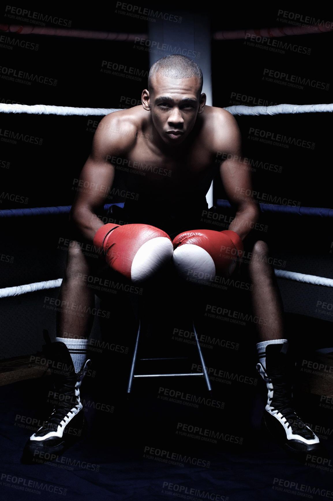 Buy stock photo Confident African American male athletic sitting in ring wearing gloves