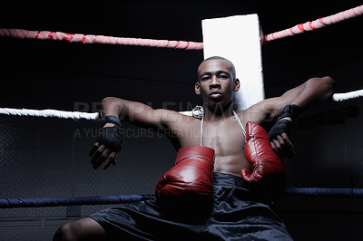 Buy stock photo African American boxer sitting with boxing gloves hanging on neck
