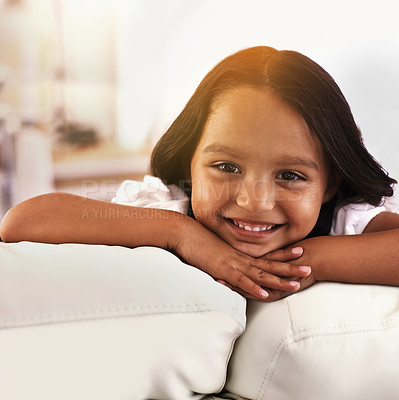 Buy stock photo Home, relax and portrait of child on sofa for playful, fun and resting on weekend in living room. Happy, childhood and face of young girl alone on couch for chilling, comfort and smile in Brazil