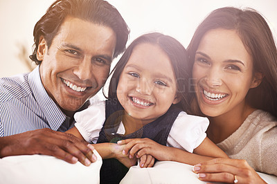 Buy stock photo Happy family, portrait and sofa for love, bonding or care in relax together at home. Face of interracial mother, father and little girl or daughter with smile in living room for weekend at house