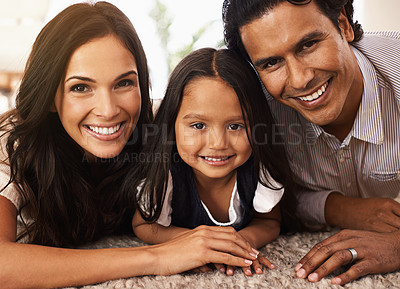 Buy stock photo Happy family, portrait and hug with love for bonding, support or relax together at home. Face of mother, father and little girl, child or young kid with smile for embrace, holiday or weekend on floor