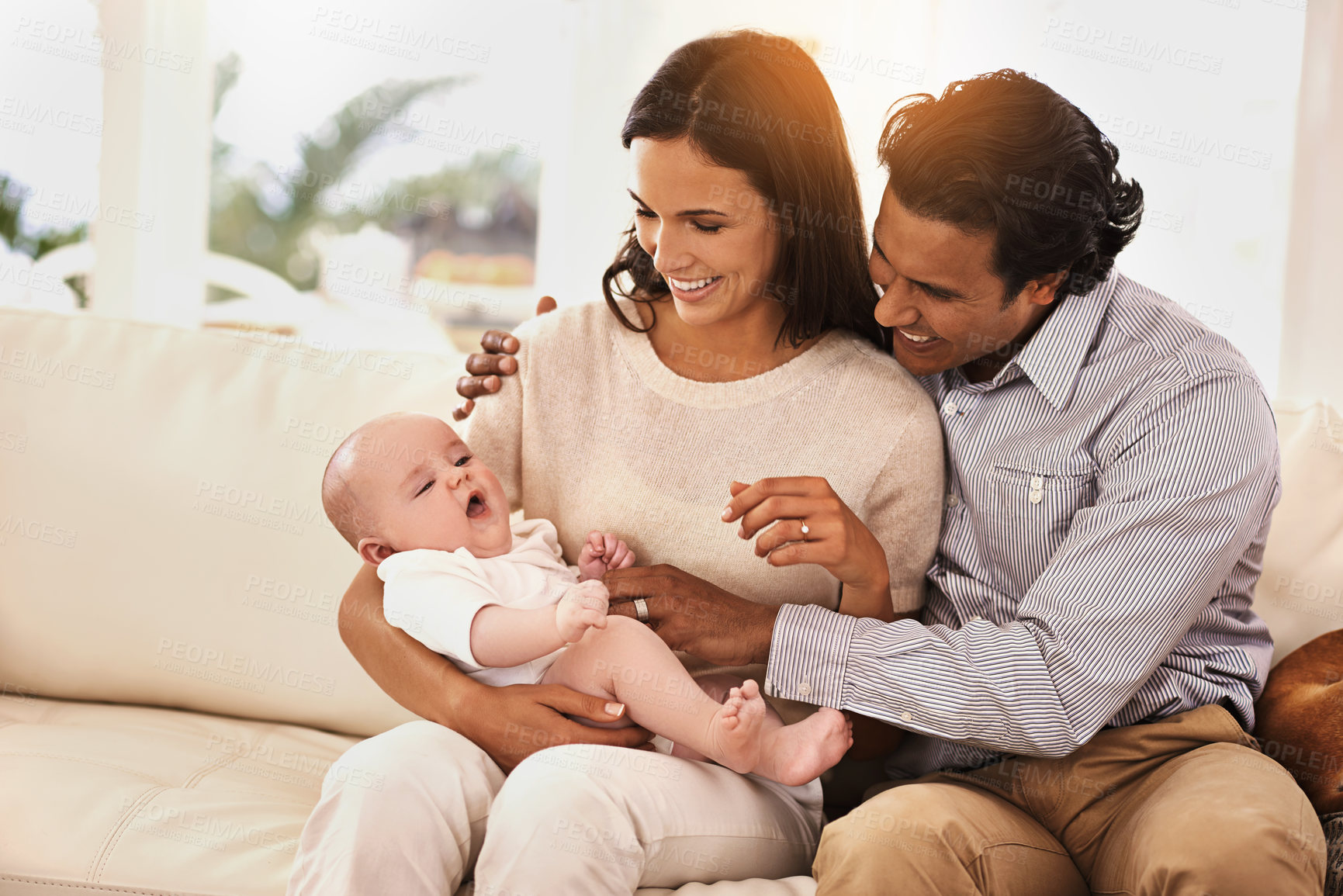 Buy stock photo Happy family, baby and hug on sofa for bonding, support or love together in relax at home. Father and mother holding little child, kid or newborn toddler on living room couch with smile at house