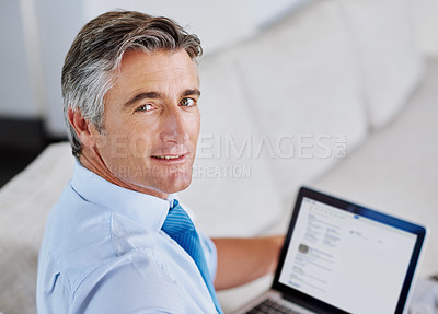 Buy stock photo Portrait of a mature businessman using a laptop while sitting on a sofa