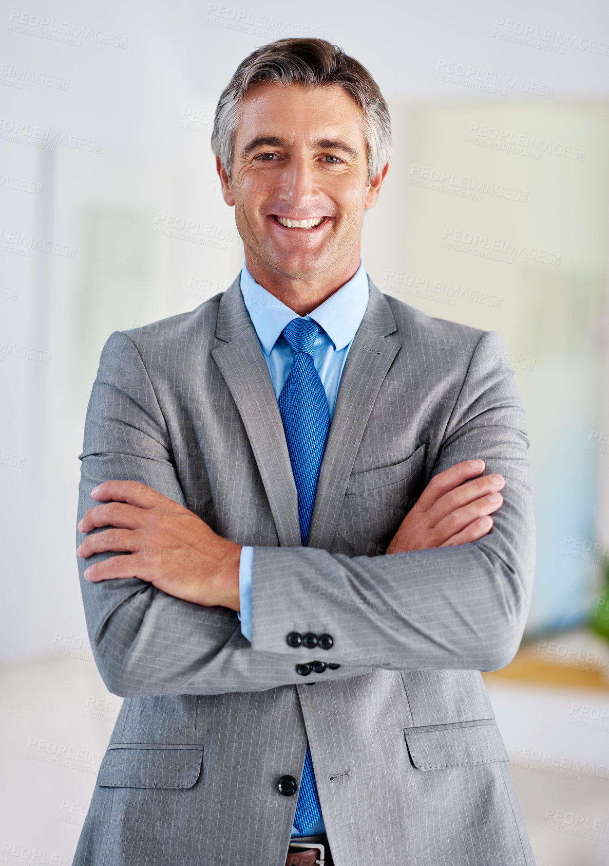 Buy stock photo Portrait of a smiling mature businessman standing with his arms crossed