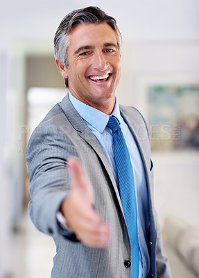 Buy stock photo Portrait of a smiling mature businessman extending his arm to shake hands