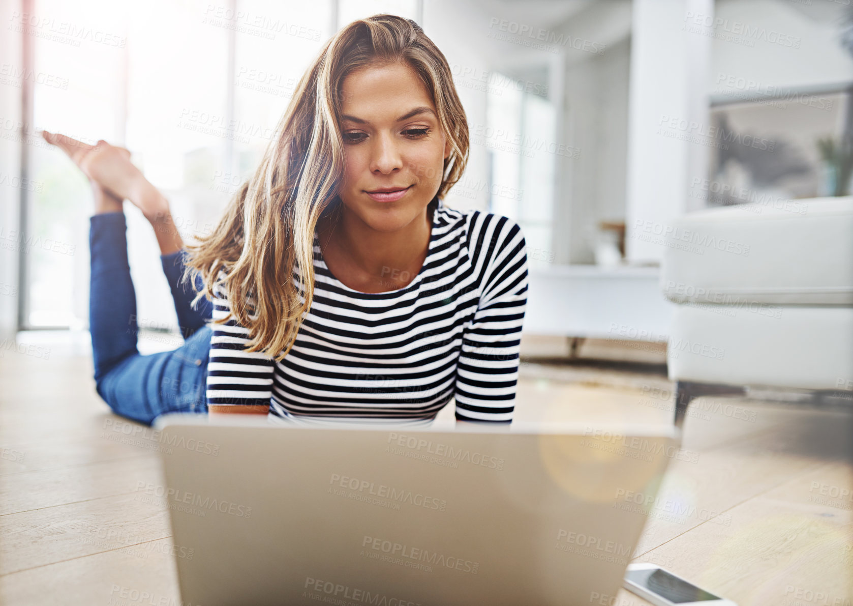 Buy stock photo Woman, relax and lying with laptop on floor in living room with streaming, video and subscription in home. Person, computer and happy with search, smartphone and check notification on social media