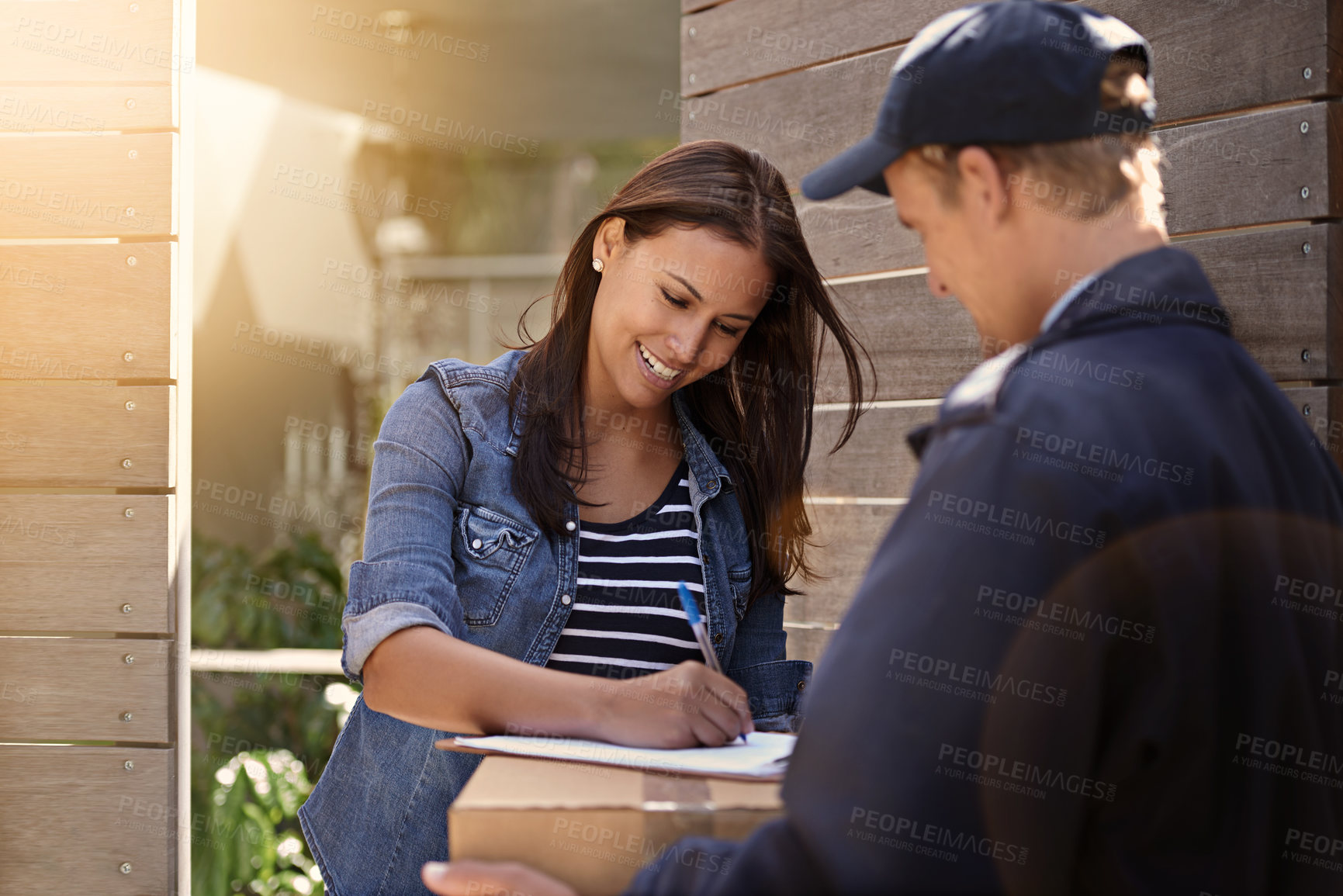 Buy stock photo Cropped shot of a young woman receiving a delivery