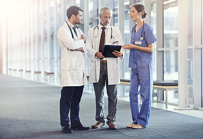 Buy stock photo Shot of a medical team looking at a patient's chart