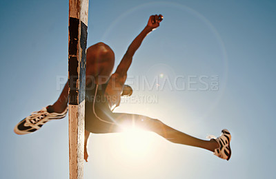 Buy stock photo Low angle shot of an athletic practicing high jump