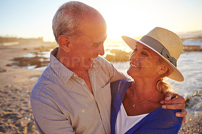 Buy stock photo Shot of an affectionate senior couple walking on the beach