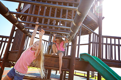 Buy stock photo Shot of two little girls playing on a jungle gym